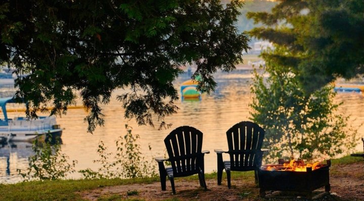 Two camping chairs and a fire in front of the beach