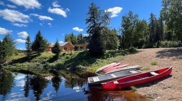 Chalet avec un canot sur le bord de l'eau