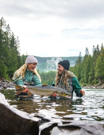 Deux femmes pêchant un poisson 