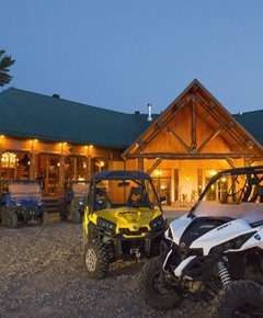 Several quads in front of an hotel in forest.