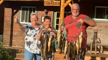 Des grands-parents avec leur petit-fils présentant leurs poissons