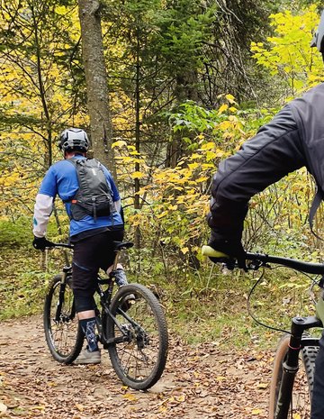Two men ride their bikes to an outfitter.