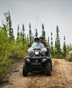 Two people on a ATV in the forest 
