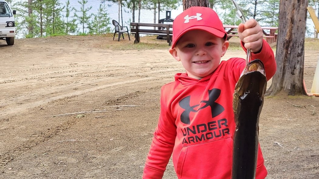 Un petit garçon qui présente son brochet 