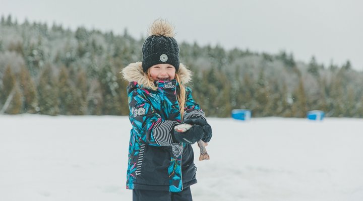 [Translate to English:] Petite fille qui a pêché un poisson en hiver 