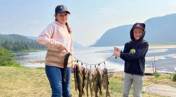 Two children showing off their fish