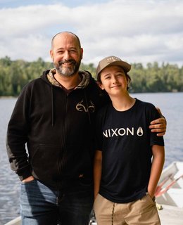 Un père et son fils devant un lac 