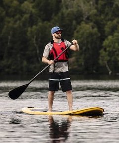 A man standing on a paddleboard on a lake.