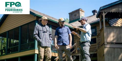 Trois hommes discutent devant un chalet avec logo FPQ